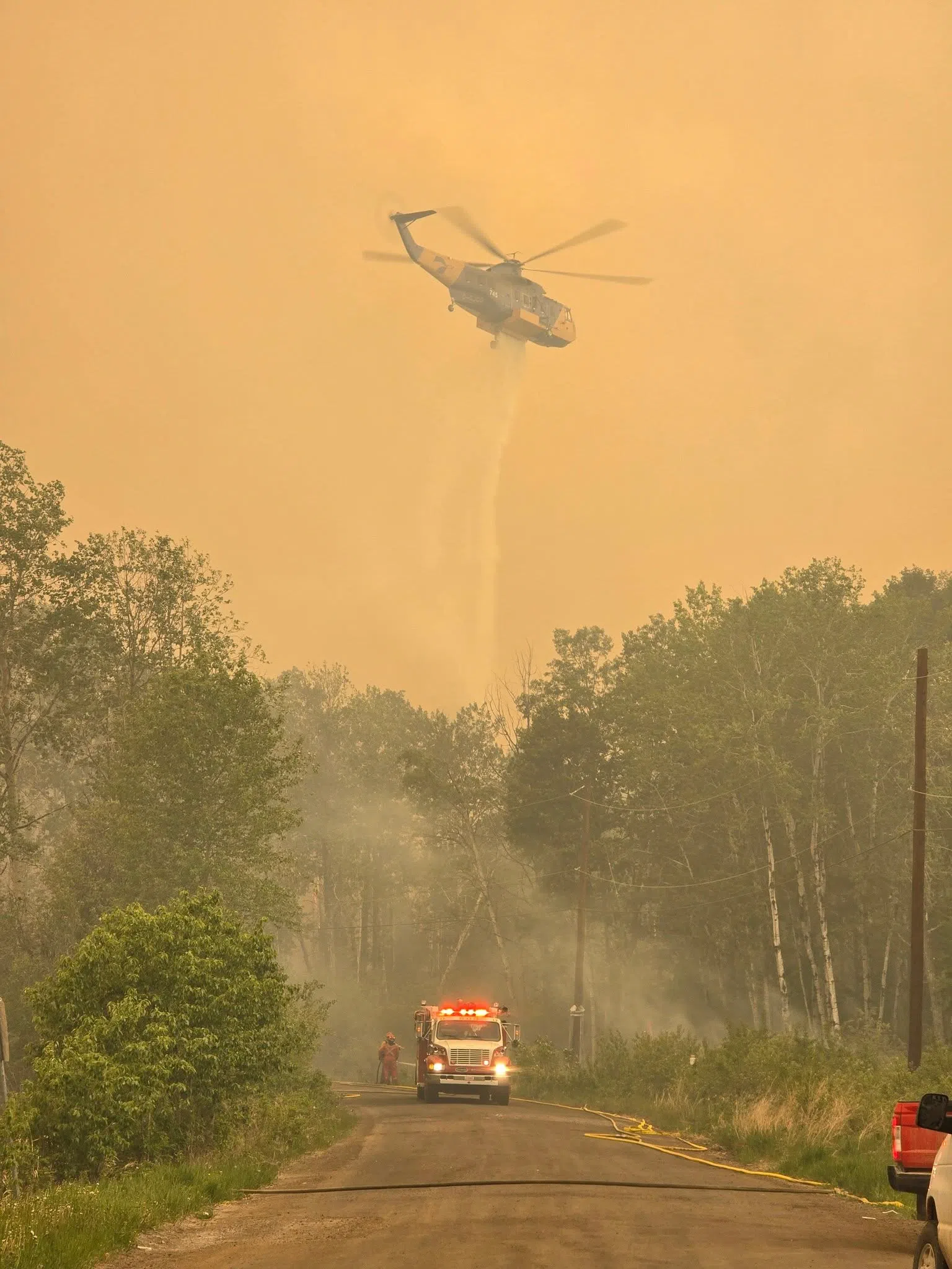 Aerial and ground crews work together to tackle the flames. (La Ronge and District Fire Department/Facebook)