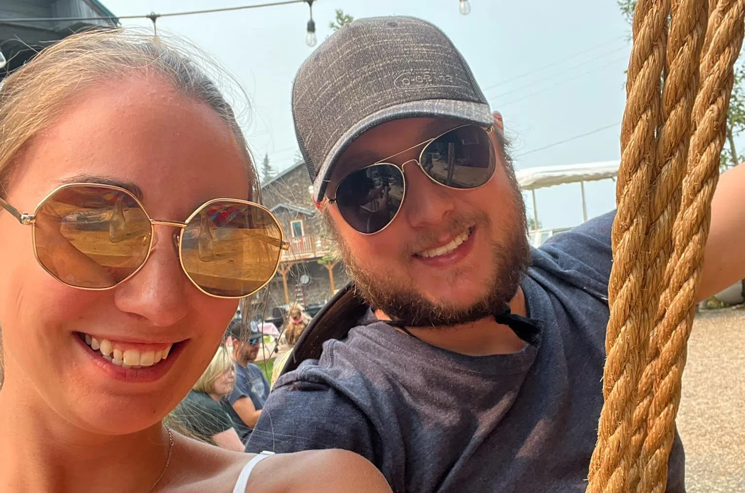 A young couple wearing sunglasses smiling for a selfie