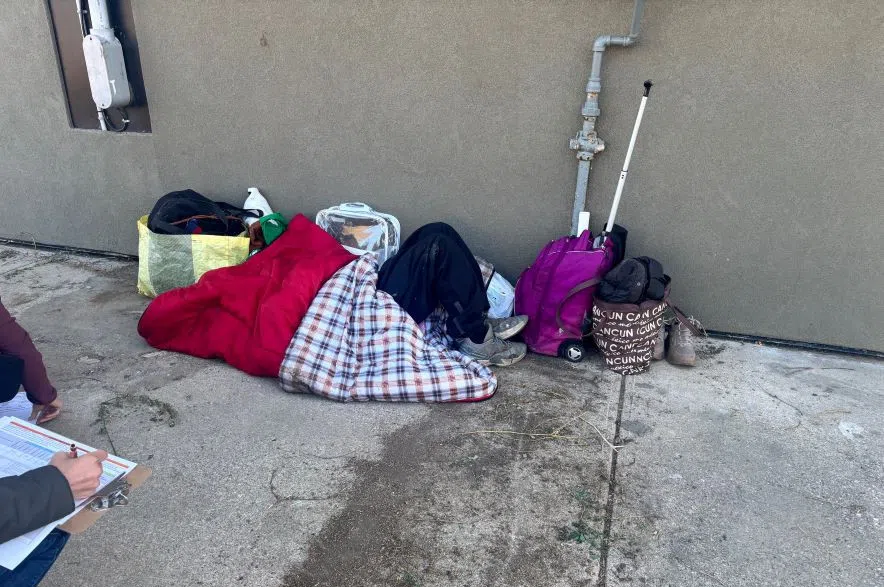 A woman in a sleeping bag on the ground.