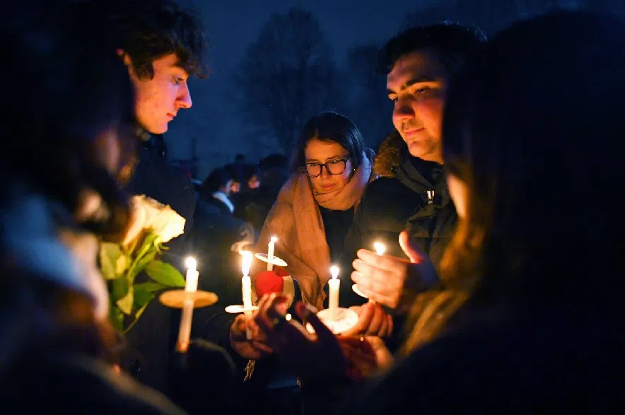 People hold candles during a vigil, Sunday, Dec. 14, 2025, in Providence, R.I., for those injured or killed during the Saturday shooting on Brown University campus.