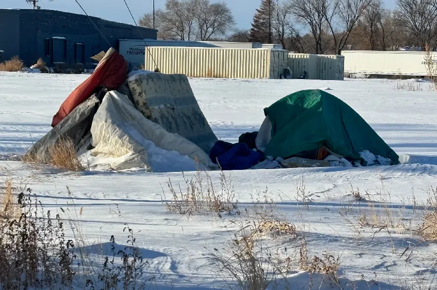 A lone tent in a field along Avenue N South with an occupant inside.