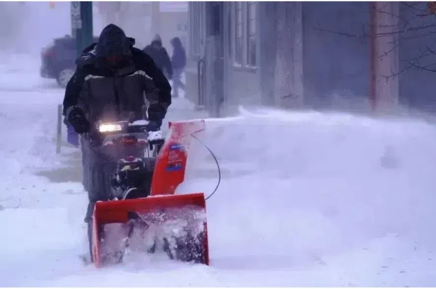 snowblower clears sidewalk