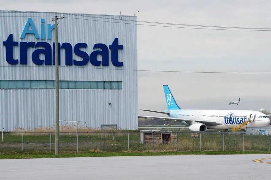 An Air Transat plane is seen as an Air Canada plane lands at Pierre Elliott Trudeau International Airport in Montreal on Thursday, May 16, 2019.