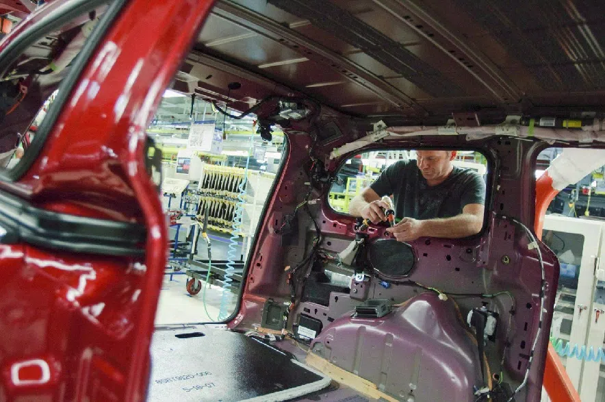 A worker installs parts on the production line at Chrysler's plant, in Windsor, Ont., in a January 18, 2011, file photo.
