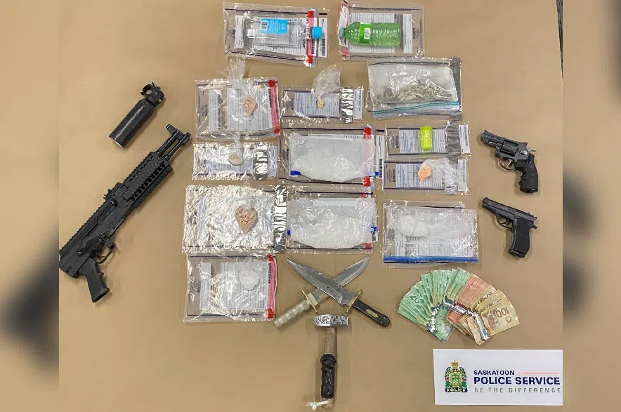 Drugs, weapons and cash seized by Saskatoon police, arrayed on a table for display.