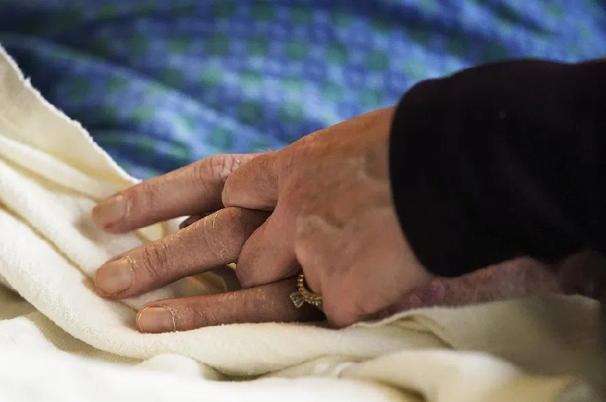 A patient's hand is held at a hospital in Minneapolis on Monday, May 3, 2021.