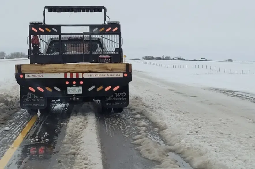 A truck driving down a slushy highway on a warm winter day in Saskatchewan.