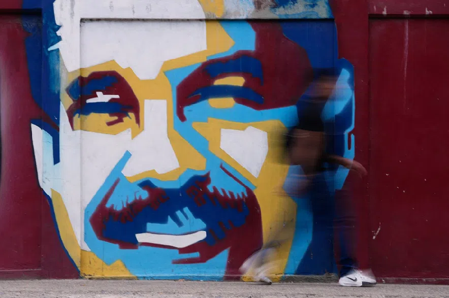 A pedestrian walks past a mural of Venezuelan President Nicolas Maduro in Caracas, Venezuela, on Sunday, Jan. 4, 2026.