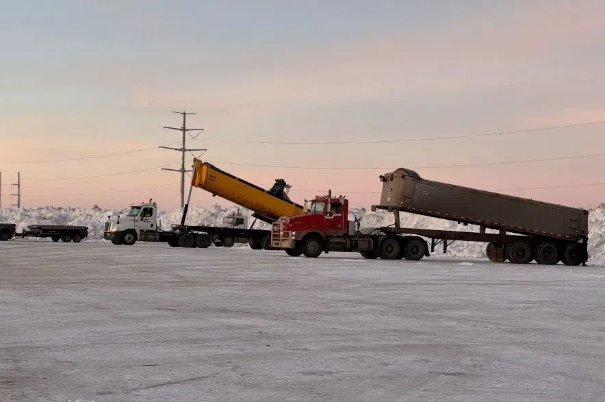 Trucks dump snow at a storage site in Saskatoon.