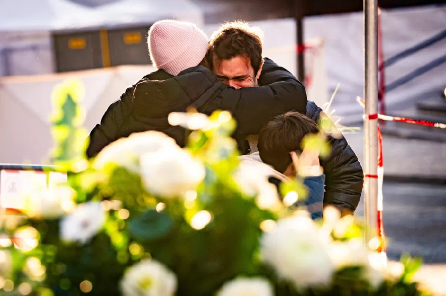 People cry at the scene after a fire broke out at the Le Constellation bar and lounge during New Year's celebration, in Crans-Montana, Switzerland, Thursday, Jan. 1, 2026.