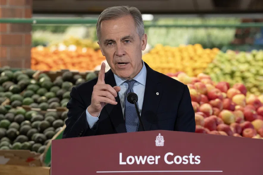 Prime Minister Mark Carney makes a point as he answers a question from media during an event at a grocery store in Ottawa on Monday, Jan. 26, 2026.