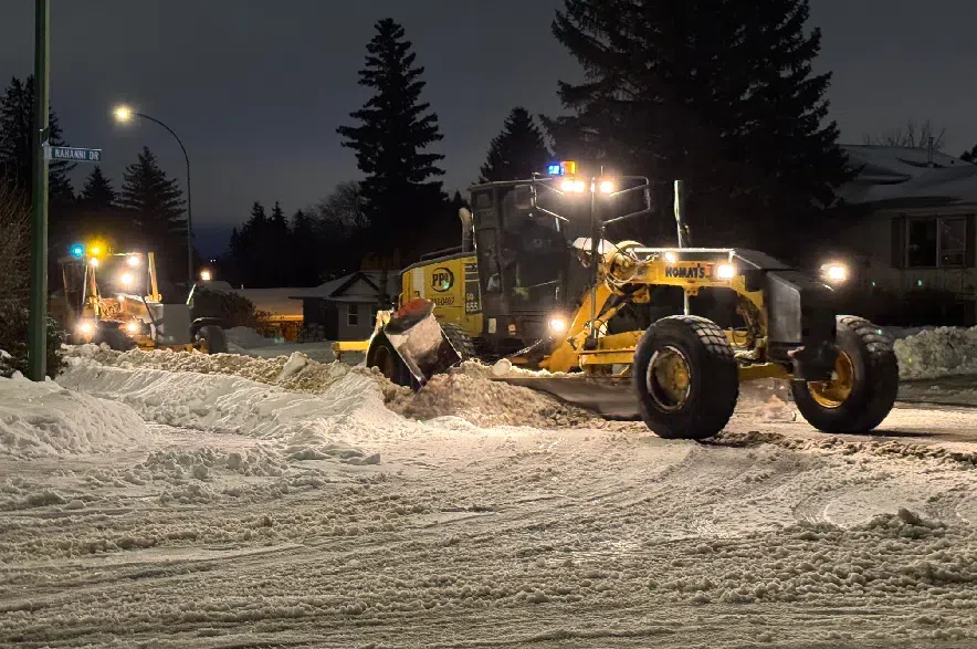 Two graders moving snow on a residential street in Saskatoon.
