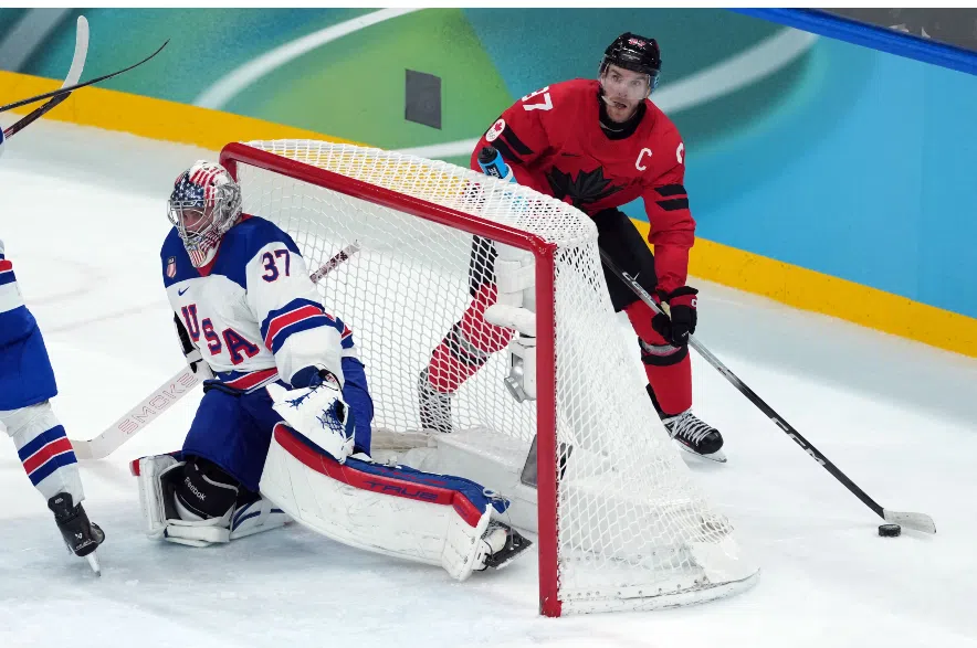 Connor McDavid (97) looks to pass behind United States goalie Connor Hellebuyck.