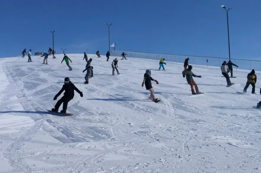 Snowboarders ride down the hill together during Optimist Hill's opening day on Feb. 10, 2019.