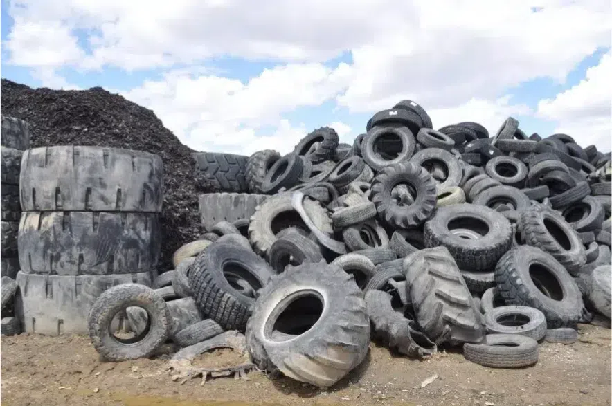 Pictured is a pile of tires in a yard.
