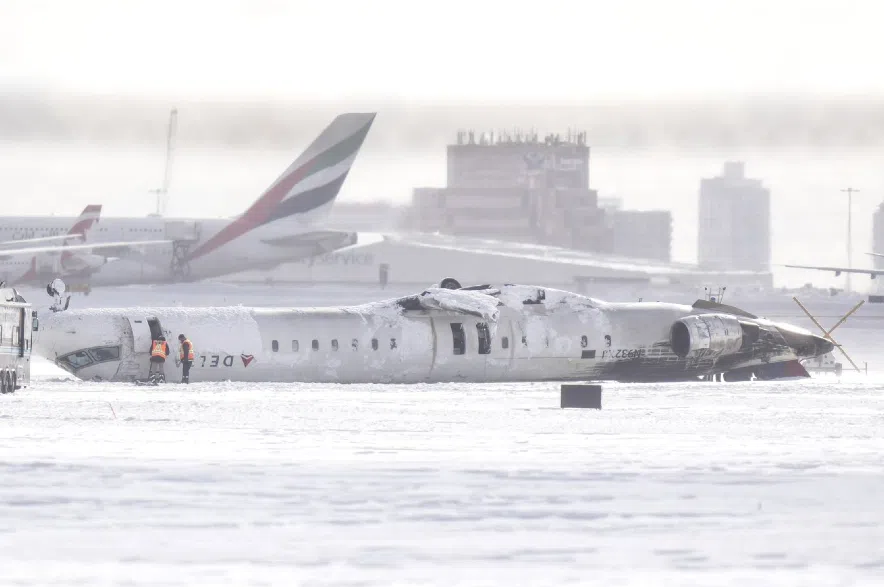 A Delta Air Lines plane lies upside down at Toronto Pearson Airport.