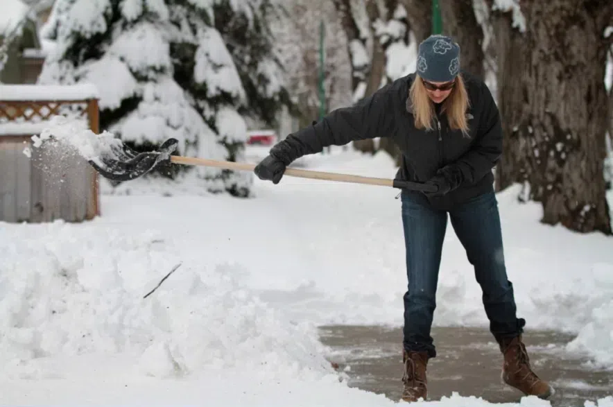 A woman shovels snow in Saskatoon.
