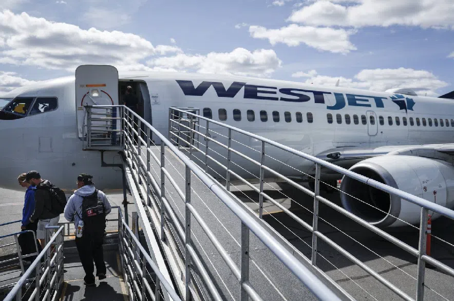 Westjet passengers deplane on the tarmac at Yellowknife Airport on Tuesday, July 22, 2025.