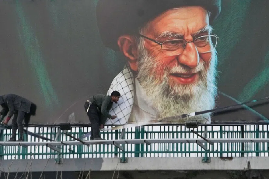 Workers install a billboard on an overpass containing a portrait of the late Iranian Supreme Leader Ayatollah Ali Khamenei, who was killed during ongoing joint U.S.-Israeli military attacks, in Tehran, Iran, Monday, March 2, 2026.