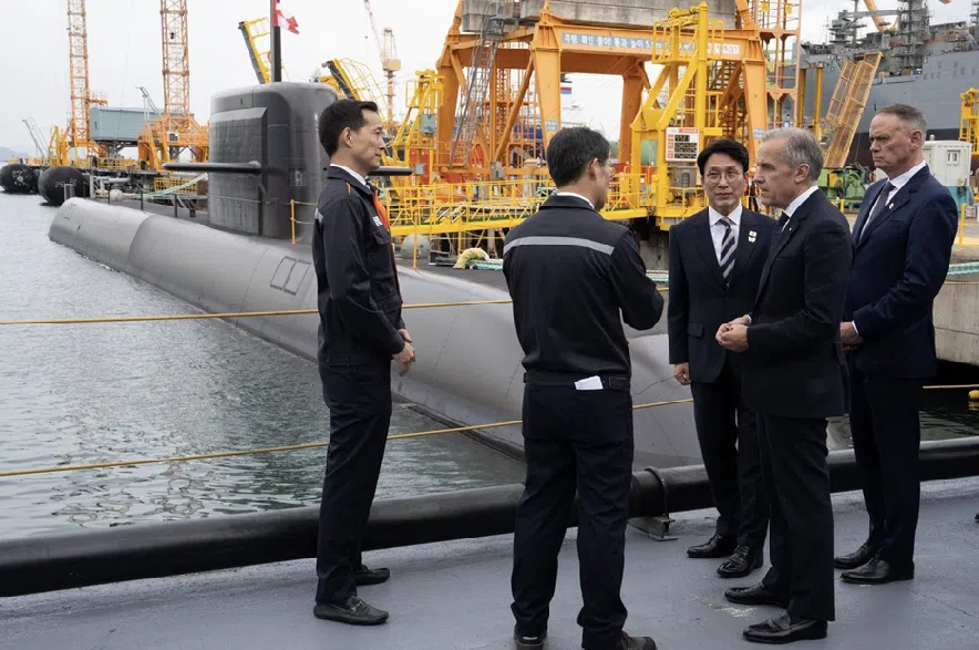 South Korea Prime Minister Kim Min-seok, centre, Prime Minister Mark Carney, second right, and National Defence Minister David McGuinty, right, are given a tour of the Hanwha Ocean Shipyard in Geoje Island, South Korea, Thursday, Oct. 30, 2025.