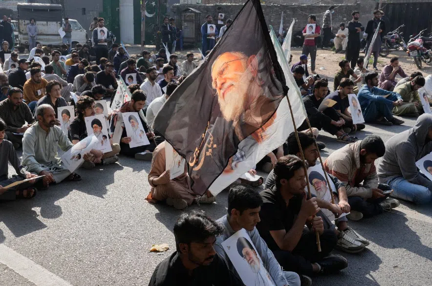 Pakistani Shiite Muslims sit on a road during a demonstration to condemn the death of Iranian Supreme Leader Ayatollah Ali Khamenei.