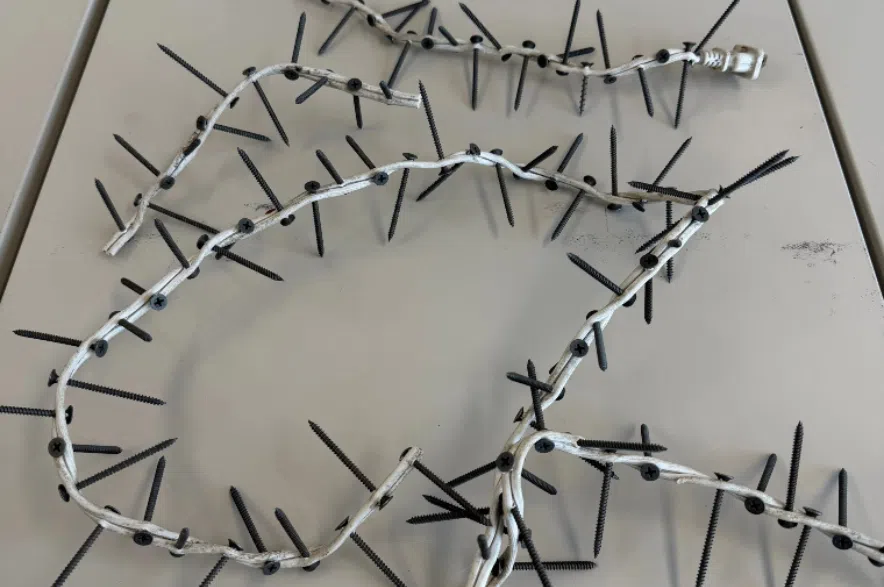 Homemade tire deflation devices made of drywall screws put through white electrical cord.