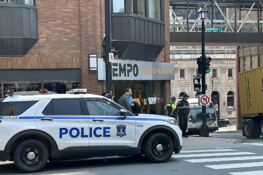 Responding to a bomb threat, police direct people to evacuate at the intersection of Barrington Street and Duke Street, in downtown Halifax, on Monday, Aug. 10, 2026.