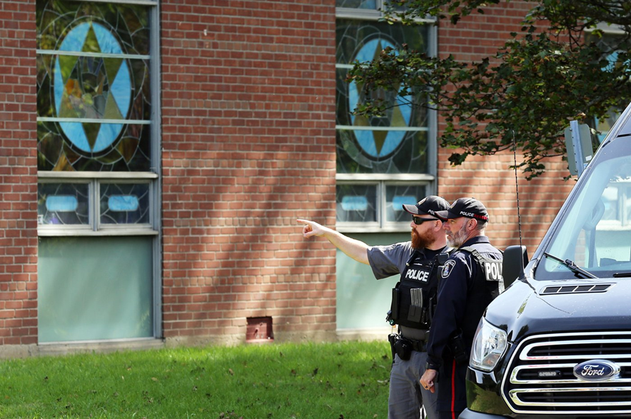 Police stand in front of the Sons of Jacob Synagogue in Belleville, Ontario Ontario on Monday Sept. 21, 2026. A man armed with a shotgun allegedly opened fire at a police officer stationed outside a synagogue in Belleville, Ont., on Sept. 20.