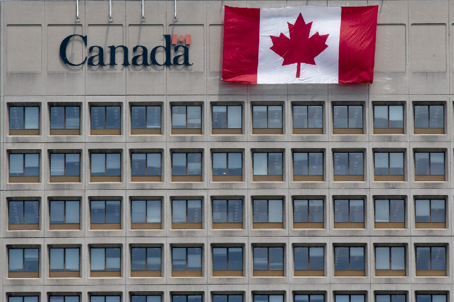 A giant Canadian flag hangs on the side of a government office building in downtown Ottawa, Tuesday, June 30, 2020.