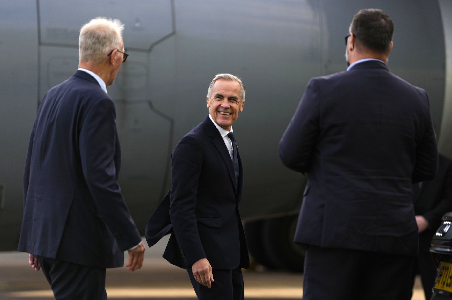 Prime Minister Mark Carney speaks with High Commissioner for Canada in the United Kingdom Bill Blair, left, as he arrives in Manchester, England, on Wednesday, Sept. 16, 2026.