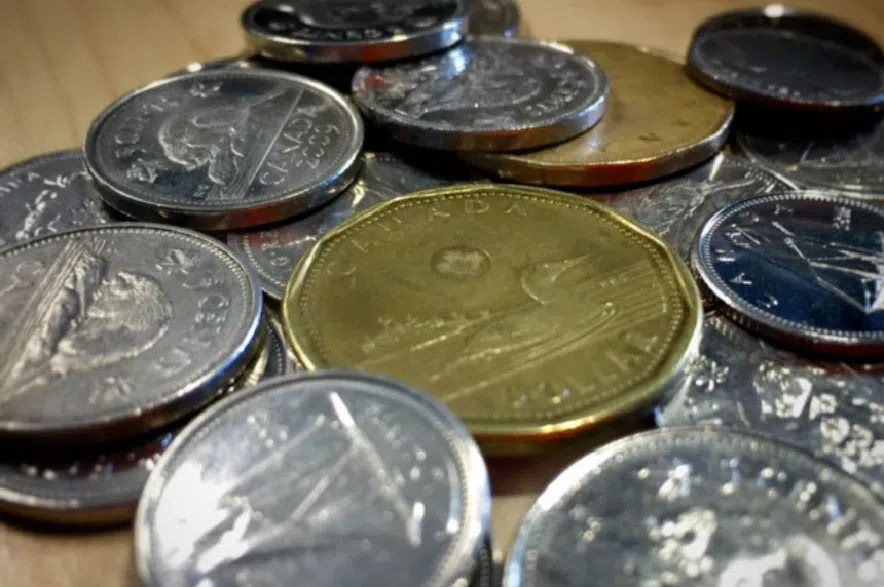 Canadian coins, including a loonie, nickels, and dimes, laid out on a table.