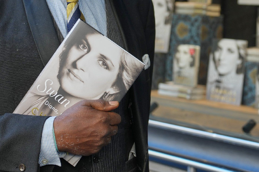 A man holds a copy of the new book by Earl Spencer, brother of the late Princess Diana, entitled Swan Song: Diana, My Sister, outside a bookshop in central London, Tuesday, Sept. 22, 2026.