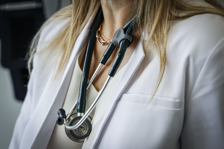 A doctor wears a lab coat and stethoscope in an exam room at a health clinic in Calgary, Friday, July 14, 2023.