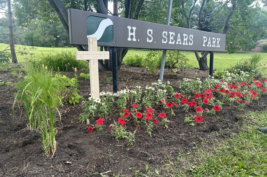 A cross next to flowers outside of H.S. Sears Park to remember Harvey Zoerb in 2024.