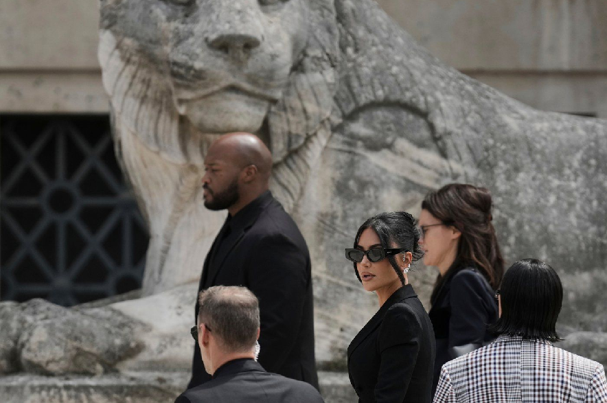 Kim Kardashian, center, arrives to testify regarding a robbery of millions of dollars in jewels from her Paris hotel room in 2016, in Paris on May 13, 2025.