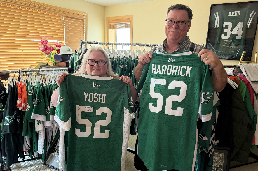 Donna Ryhorchuk poses with two of her Roughrider jerseys.