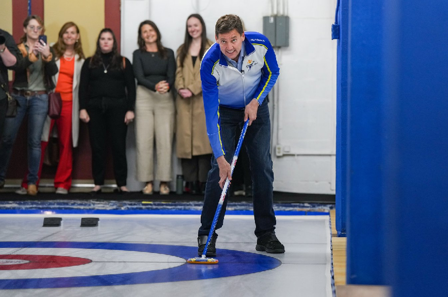 B.C. NDP Leader David Eby waits to receive a rock being thrown by Saanich South NDP candidate Richard Zussman, not seen, during a provincial election campaign stop at the Victoria Curling Club, in Victoria, B.C., on Monday, Oct. 5, 2026.