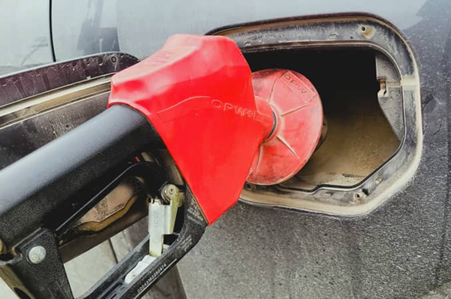 A person pumps gas into a vehicle.