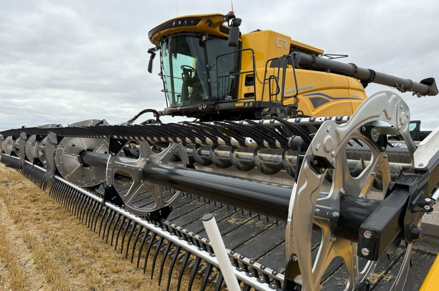 A yellow combine harvester parked in a Saskatchewan grain field.