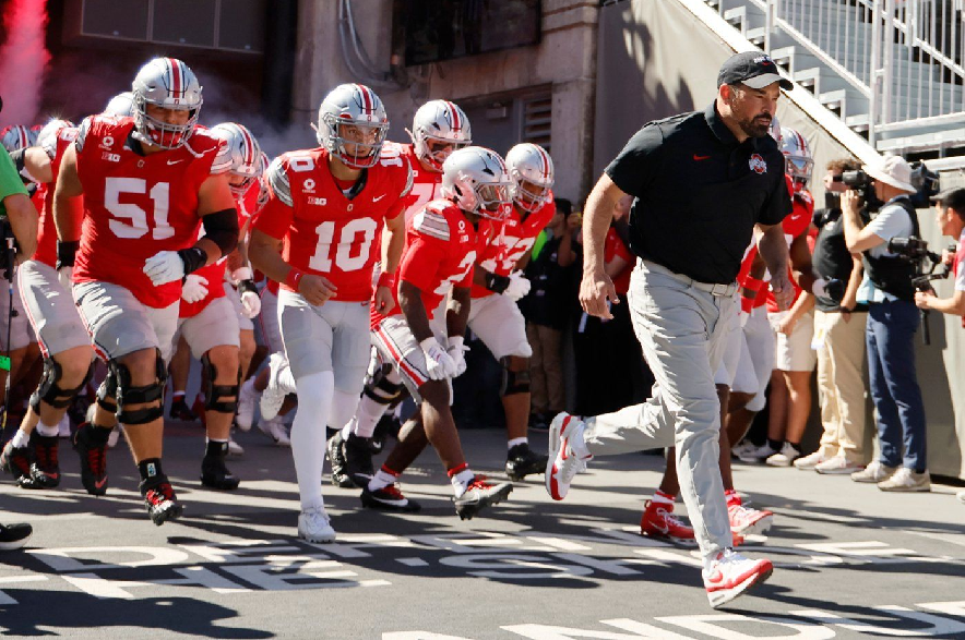 Ohio State head coach Ryan Day, right, leads the team onto the field for the start of an NCAA college football game against Illinois, Saturday, Sept. 26, 2026, in Columbus, Ohio.