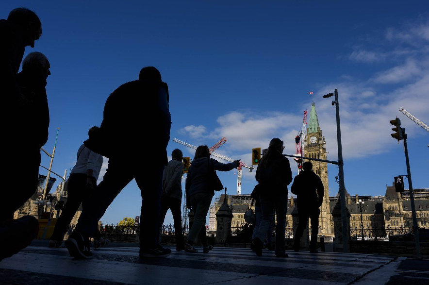People cross Wellington Street on their way to Parliament Hill, a day before the return of the House of Commons, on Sunday, Sept. 14, 2025.