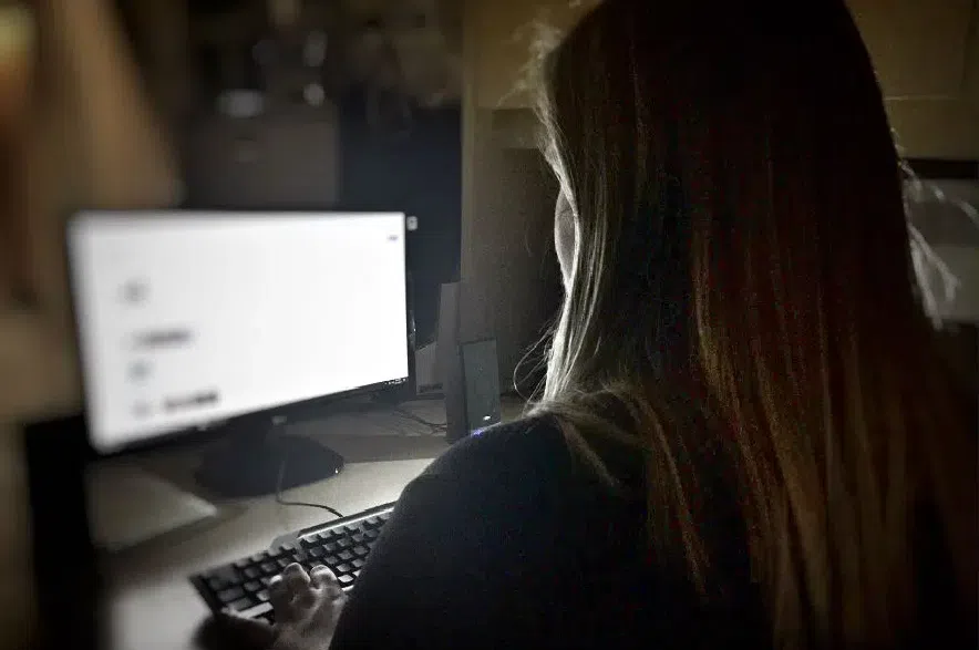 A woman uses a PC in a dark room.