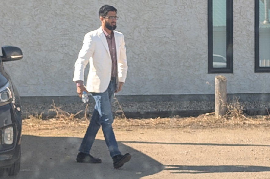 Mohammad Masum walking through a parking lot.