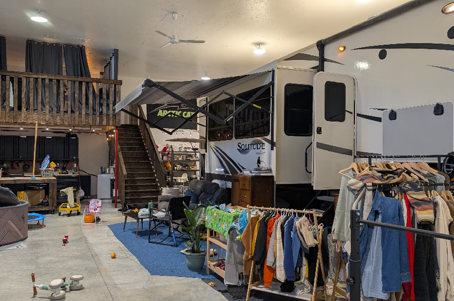 A trailer inside a shop, being used as a makeshift home.