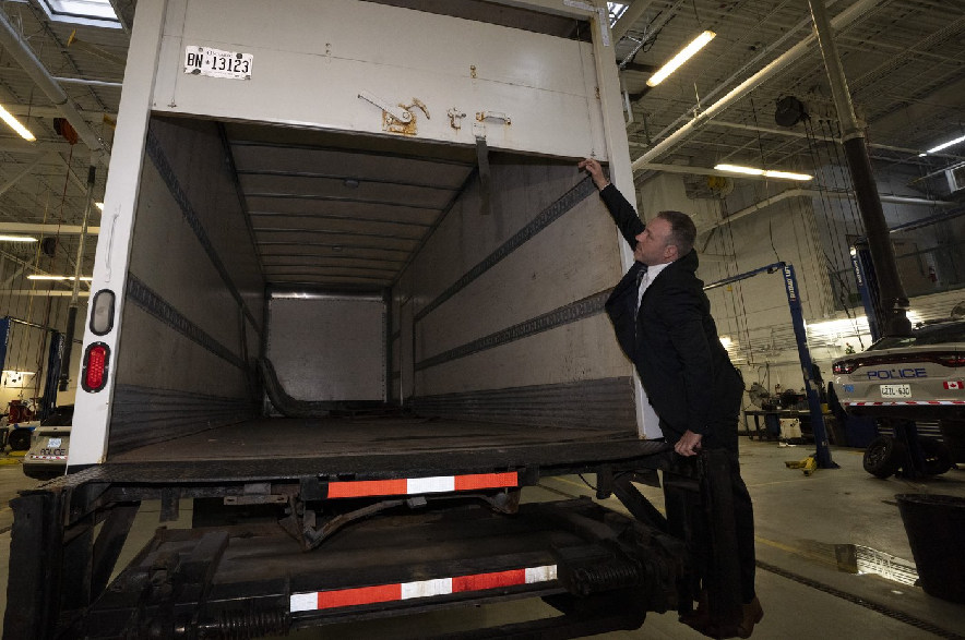 Police officers open the back of a recovered truck during a press conference regarding Project 24K a joint investigation into the theft of gold from Pearson International Airport, in Brampton, Ont., on Wednesday, April 17, 2024.