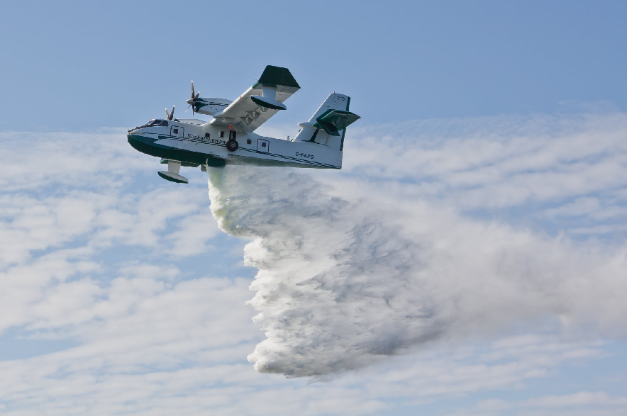 A Saskatchewan water bomber drops onto a wildfire.
